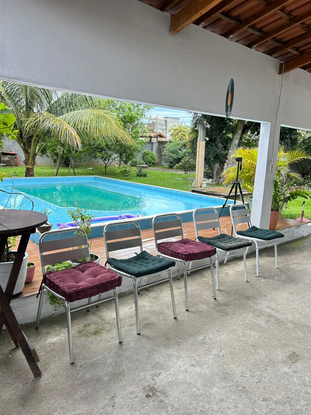 Varanda coberta da Casa Aurora com vista para o quintal e piscina